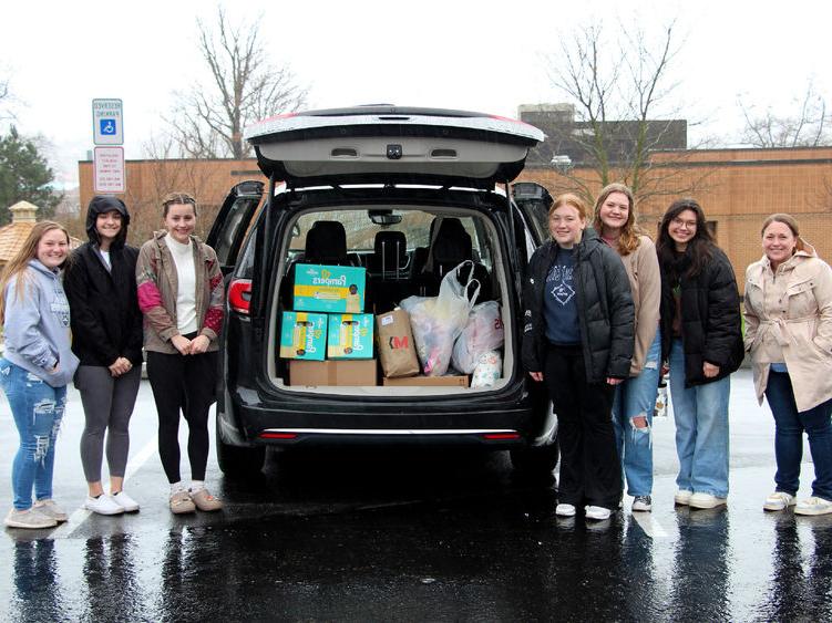 Members of the HDFS club at <a href='http://yidgkv.grapevilla.com'>365英国上市</a>杜波依斯分校 stand next to the vehicle loaded with their donation items prior to their trip to the 你好邻居 location in Pittsburgh.